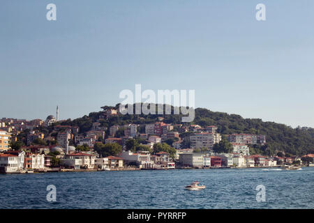 View of a small, wooden fishing boat on Bosphorus and the Asian side of Istanbul. Stock Photo