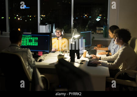 Group of Computer Programmers Coding at Night Stock Photo