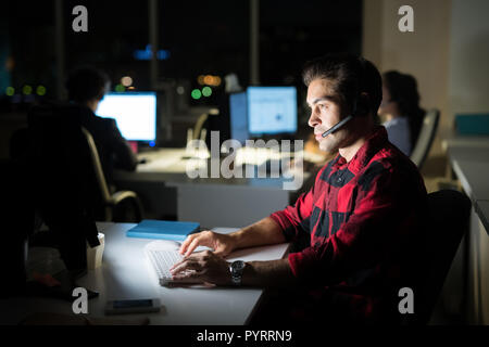 Help Desk Operator Working at Night Stock Photo