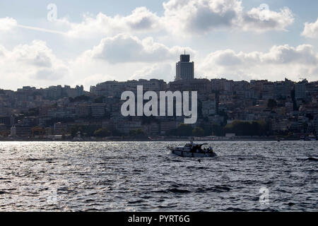 Small yacht on Bosphrous strait of Istanbul. Buildings on European side are in the background. Stock Photo