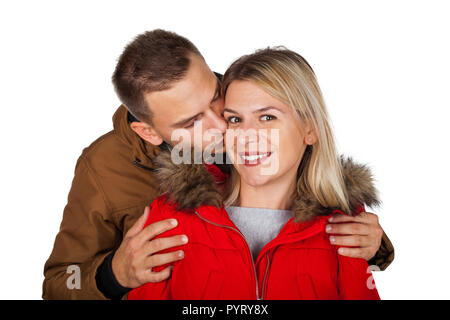 Couple wearing winter clothing - red and brown hooded parka jackets - kissing on isolated background Stock Photo
