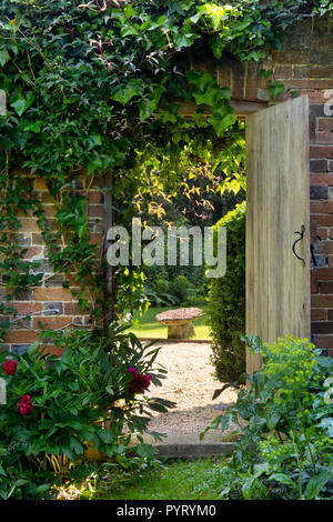 wooden doorway in wall leading into English Garden,England,Europe