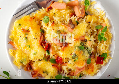 Baked risotto with mozzarella, sausages and peperoncino on plate - top view Stock Photo