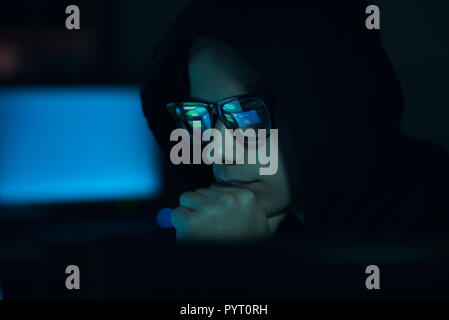 Young professional hacker working in a dark office with computers, cyber security and hacking concept Stock Photo