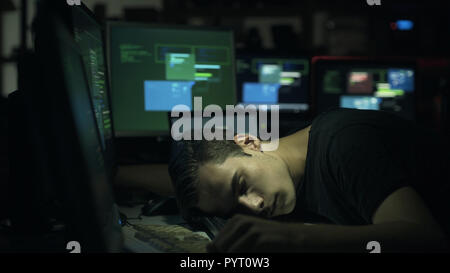 Hacker and computer developer sleeping on the desk late at night, hacking and overwork concept Stock Photo