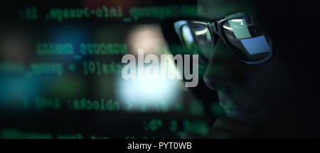 Cool hacker with sunglasses and programming code on the computer screen, cybercrime and hacking concept Stock Photo