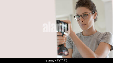Young confident woman using a drill, home renovation and DIY concept Stock Photo