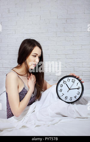 Happy woman waking up and turning off the alarm clock Stock Photo
