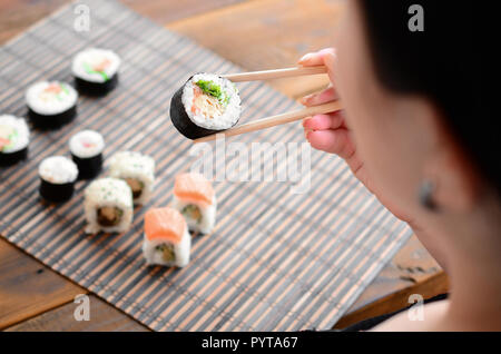 chopsticks and sushi roll on bamboo mat. background menu Stock Photo - Alamy