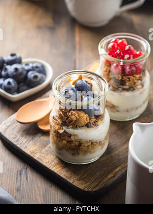 Cozy Breakfast concept on dark wooden textured background. Coffee and yogurt with home made granola Stock Photo