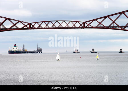 The Forth Rail Bridge Crossing the Firth of Forth with a the Crude Oil Tanker Bukha Discharging Oil at South Queensferry Edinburgh Scotland UK Stock Photo