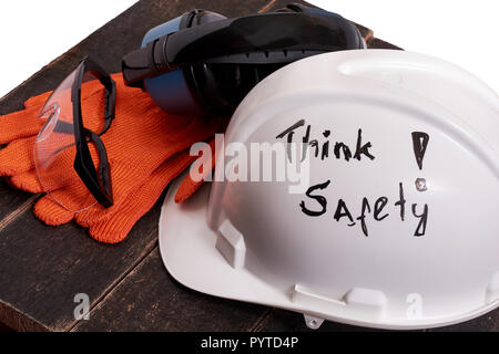 Safety personal protective euipment (helmet, gloves, glasses, ear protection) on a black wooden table on white isolated background. Safety first conce Stock Photo