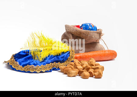 Items concerning the Dutch holiday of Sinterklaas. Carrot for the horse, sweets, bag with presents and the hat of Zwarte Piet Stock Photo