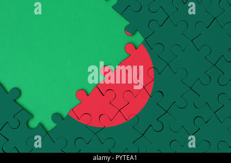 Bangladesh flag  is depicted on a completed jigsaw puzzle with free green copy space on the left side. Stock Photo