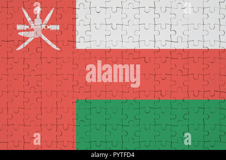 Oman flag  is depicted on a folded puzzle Stock Photo