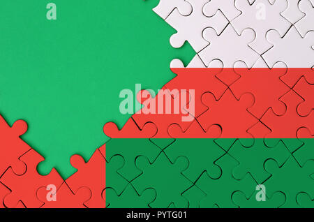 Oman flag  is depicted on a completed jigsaw puzzle with free green copy space on the left side. Stock Photo