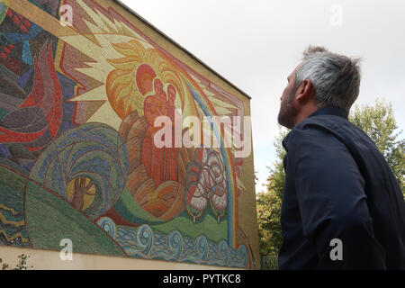 A tourist looks at a Soviet-era mosaic mural monument commemorating Taras Shevchenko who was a notable Ukrainian poet and writer made by artist V. Kutkin in1970. placed in the center of Tashkent capital of Uzbekistan Stock Photo