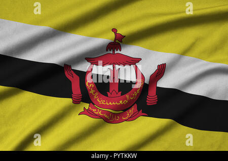 Brunei Darussalam flag  is depicted on a sports cloth fabric with many folds. Sport team waving banner Stock Photo