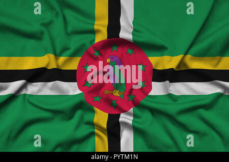 Dominica flag  is depicted on a sports cloth fabric with many folds. Sport team waving banner Stock Photo