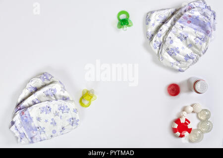 Babies goods diaper, soother or nipple on white background with copy space. Top view or flat lay. Stock Photo