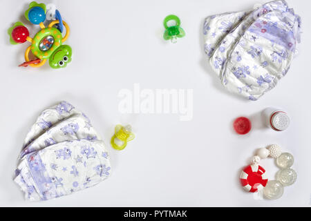 Babies goods diaper, soother or nipple on white background with copy space. Top view or flat lay. Stock Photo