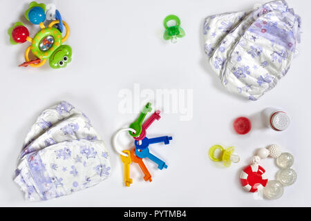 Babies goods diaper, soother or nipple on white background with copy space. Top view or flat lay. Stock Photo