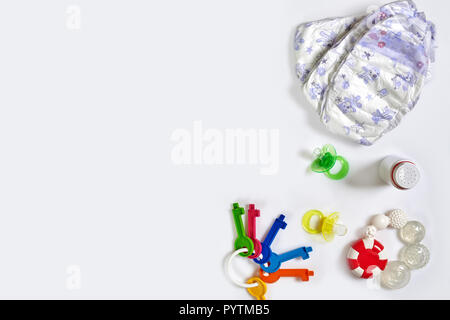 Babies goods diaper, soother or nipple on white background with copy space. Top view or flat lay. Stock Photo