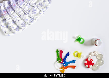 Babies goods diaper, soother or nipple on white background with copy space. Top view or flat lay. Stock Photo