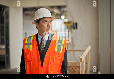 Middle aged businessman observing a construction site. Stock Photo