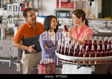 Brand representative touring a couple through a drinks factory. Stock Photo