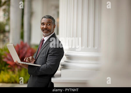 Smiling businessman using a laptop computer. Stock Photo