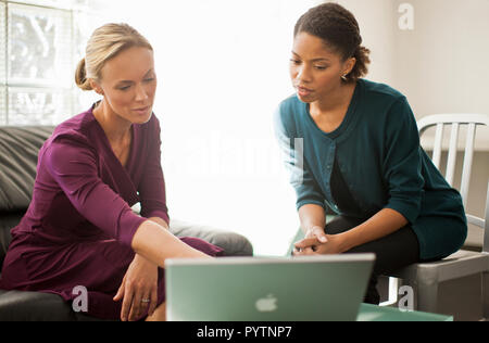 Two colleagues working together on a laptop computer. Stock Photo