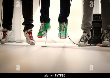 Canvas sneakers on the feet of three jumping teenage boys. Stock Photo