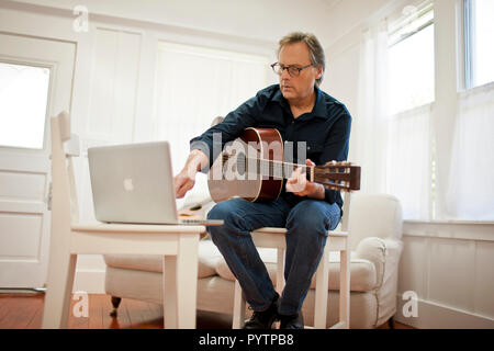 Mature man playing an acoustic guitar. Stock Photo