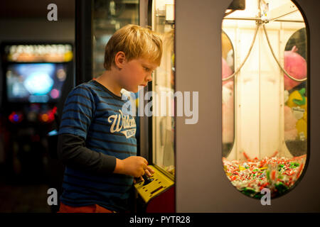 Young boy looking at an arcade game. Stock Photo
