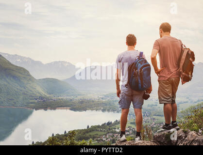 travel people, hikers standing on top of mountain and relaxing with backpacks Stock Photo
