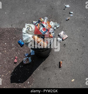 overflowing rubbish bin in park Stock Photo