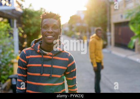Young happy slim black African man smiling with young black Afri Stock Photo