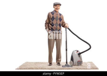 Full length portrait of a senior man standing with a vacuum cleaner on a carpet isolated on white background Stock Photo