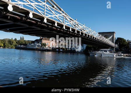 Marlow suspension bridge across the river Thames at  Marlow in Buckinghamshire, Britain .  On the opposite bank is the Complete  Angler hotel made fam Stock Photo