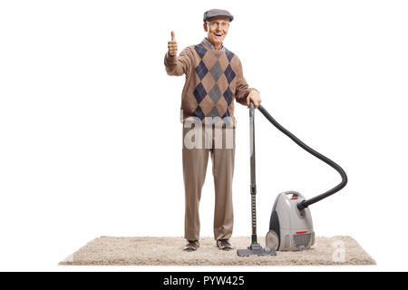 Full length portrait of a senior man standing with a vacuum cleaner and showing thumbs up isolated on white background Stock Photo