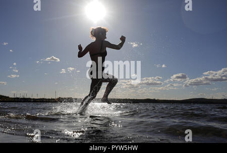 Berlin, Germany. 30th Oct, 2018. At temperatures around 22 degrees Celsius a young woman from Regensburg jumps into the cool water at the lido Müggelsee. According to the meteorologists, the coming days will also be very mild and November starts with temperatures around 15 degrees Celsius. Credit: Wolfgang Kumm/dpa/Alamy Live News Stock Photo