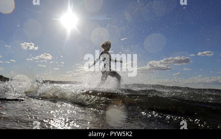 Berlin, Germany. 30th Oct, 2018. At temperatures around 22 degrees Celsius a young woman jumps into the cool water at the lido Müggelsee. According to the meteorologists, the coming days will also be very mild and November starts with temperatures around 15 degrees Celsius. Credit: Wolfgang Kumm/dpa/Alamy Live News Stock Photo