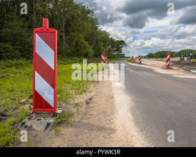 Road works with red and white warning signs Stock Photo