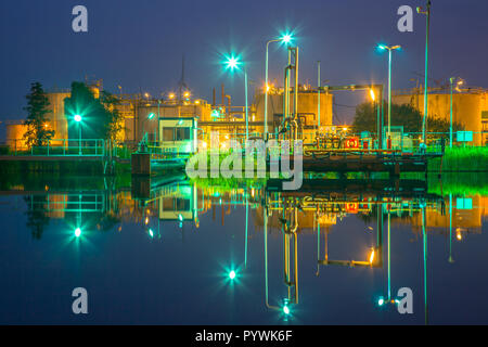Docking site near water at a small oil refinery in a chemical industrial area in twilight Stock Photo