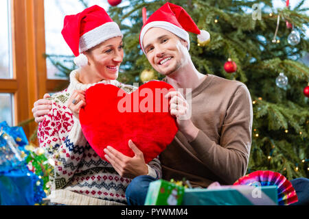 Man and woman under Christmas tree with presents  Stock Photo