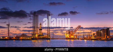 Panorama of Oil Platforms being built in a harbor under beautiful sunset Stock Photo