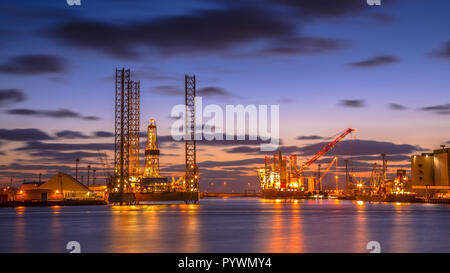 Oil Platforms being built in a manufacturing harbor under beautiful sunset Stock Photo