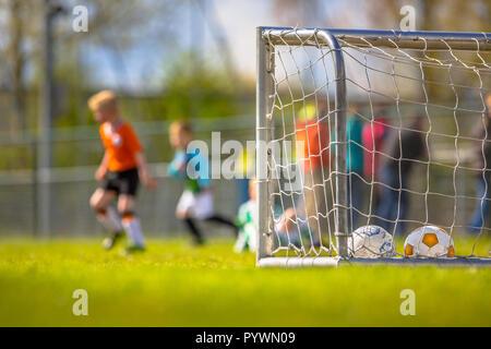 Modern aluminum soccer goal for youth with children training  in the background Stock Photo