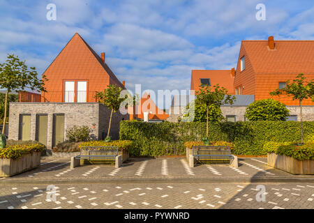 Modern houses with conspicious red slate roof tiles in a contemporary suburban neighborhood in the Netherlands Stock Photo